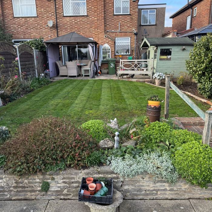 Garden maintenance with striped lawn by The Wright Exteriors